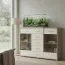 Vitrine Kavieng 13, Farbe: Eiche / Weiß - Abmessungen: 110 x 150 x 40 cm (H x B x T)